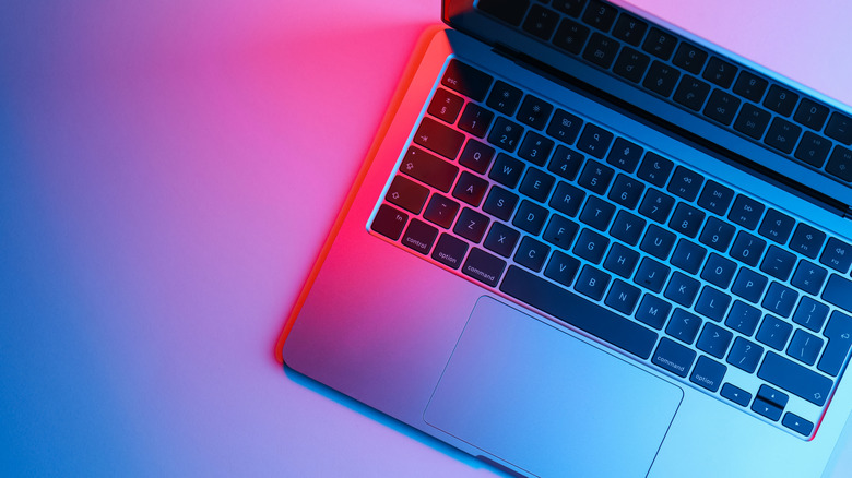 A laptop chassis glowing under vibrant blue and pink neon lights, highlighting its internal power.