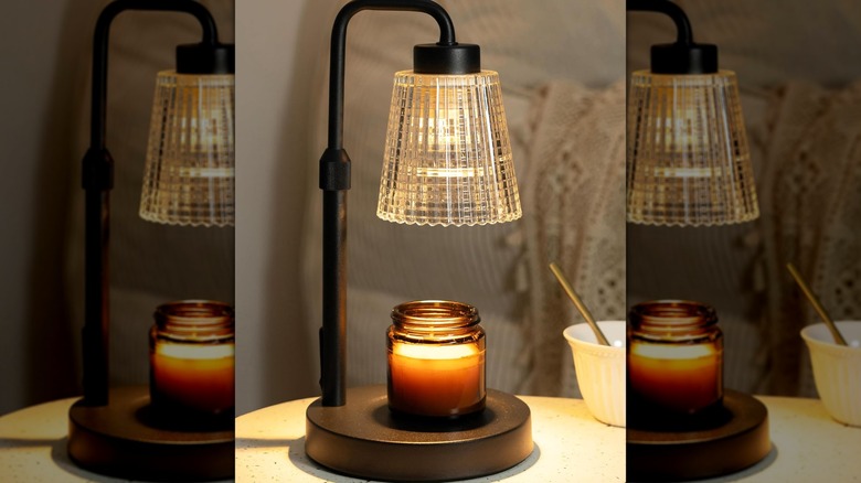 A stylish Godonlif Candle Warmer Lamp warming a jar candle on a wooden table.