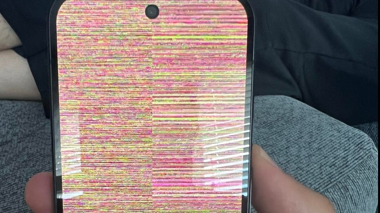 Google Pixel 10 smartphone screen glitching with rainbow snow and static pattern.