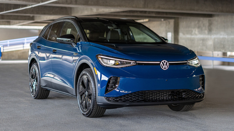 A dark blue Volkswagen ID.4 parked in a modern multistorey parking structure.