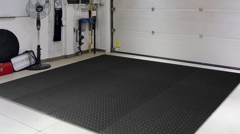 Interlocking grey garage floor mats installed on a concrete surface.