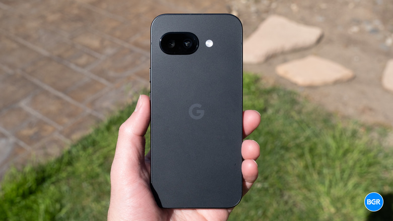 A person holding the Google Pixel 9a to demonstrate its size and matte texture.