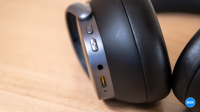 Macro view of the physical buttons and charging port on the headphone chassis.