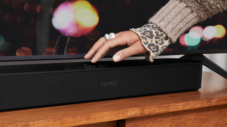 A hand resting on top of a Sonos Beam Gen 2 to demonstrate its matte finish and compact dimensions.